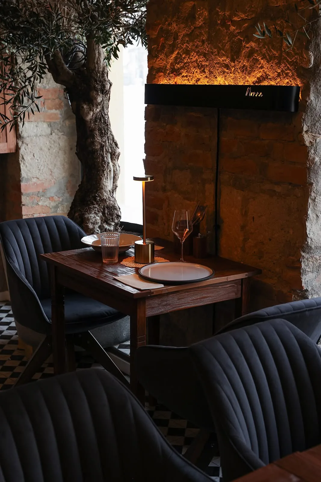 A Progetto Nonna olasz trattoria terasza Esztergomban — téglafal, olajfa és terített asztal